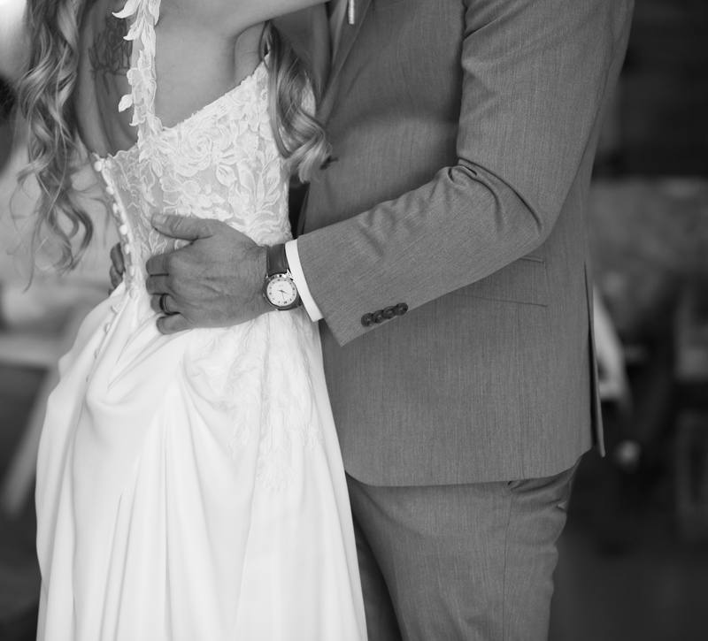 Black and white detail of a couple, her hand on his back