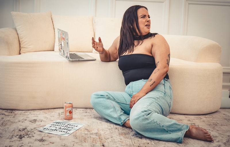 Woman working on a laptop on a curved sofa