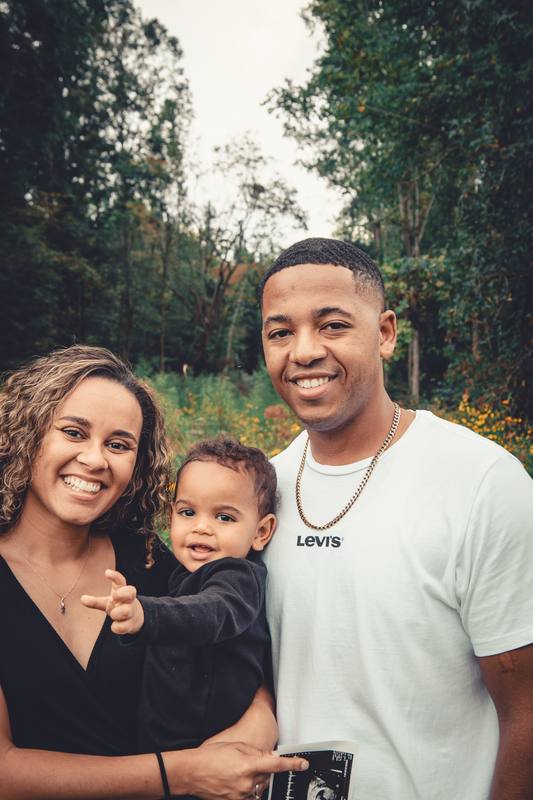 Smiling parents holding their toddler outdoors