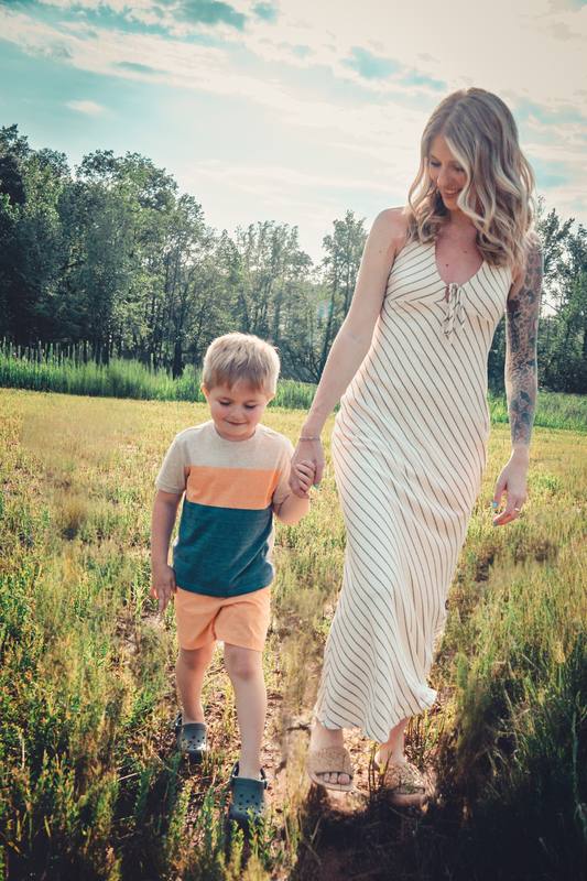 Mother and son walking through a summer field