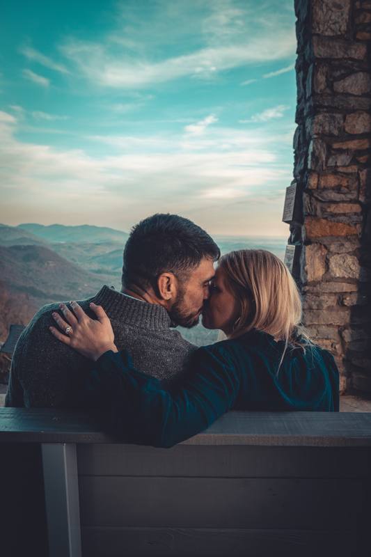 Couple on a bench above a mountain valley